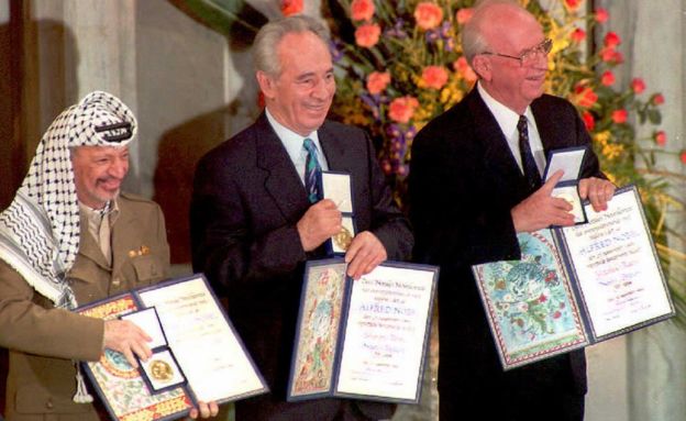 PLO leader Yasser Arafat, (L) Israeli Foreign Minister Shimon Peres and Prime Minister Yitzhak Rabin (R) show their joint 1994 Nobel Peace prize in Oslo 10 December in recognition of their historic autonomy accord