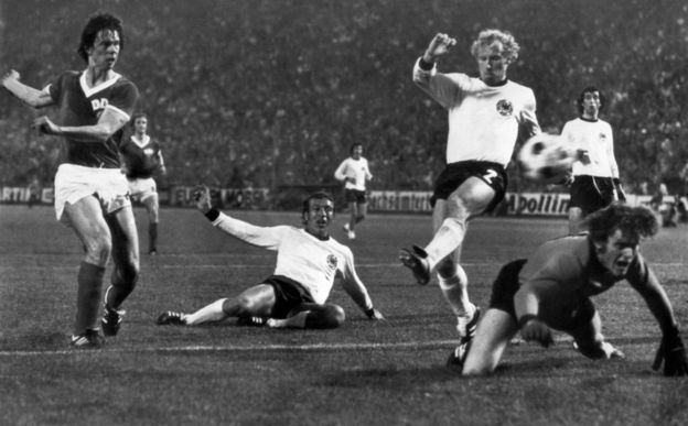 East German forward Juergen Sparwasser (L) scores the winning goal past West German defenders Horst Hoettges (C), Berti Vogts (2) and goalkeeper Sepp Maier 22 June 1974 in Hamburg during the World Cup first round soccer match between the two countries.