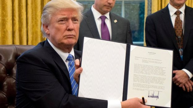 Trump con una orden ejecutiva firmada.