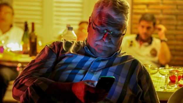 Hombre de mediana edad usando el celular