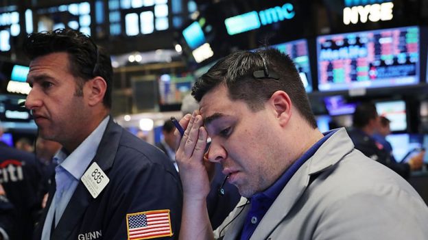Stockbrokers look concerned after a downturn in the market.