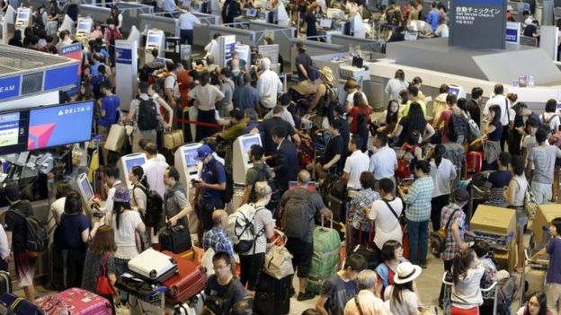 Passengers line up at check-in counter for Delta Air Lines at Narita international airport in Narita, east of Tokyo (09 August 2016)