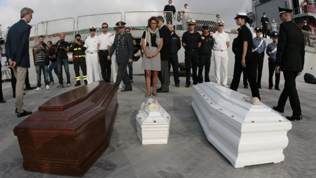 Officials pay their respect in front of the coffins of refugees arrived from Lampedusa on October 15, 2013 in Porto Empedocle near Agrigento in Sicily