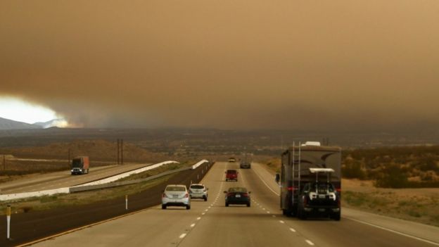 Smoke fills the sky over Interstate 15, part of which was closed