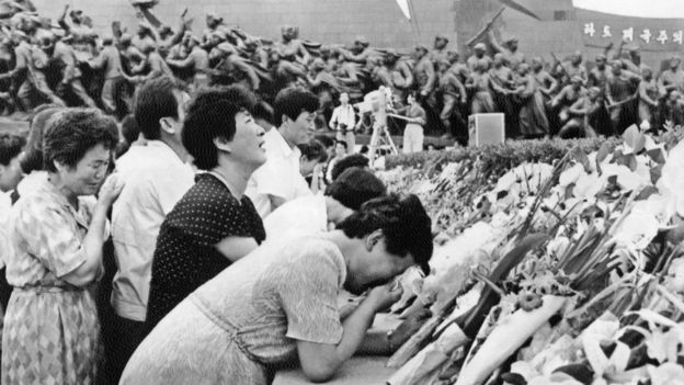 People cry after putting flowers in front of the statue of North Korean President Kim Il Sung to mourn the death of the president in Pyongyang, on July 09, 1994.