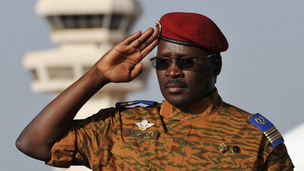 Isaac Zida in military uniform, saluting at an airport