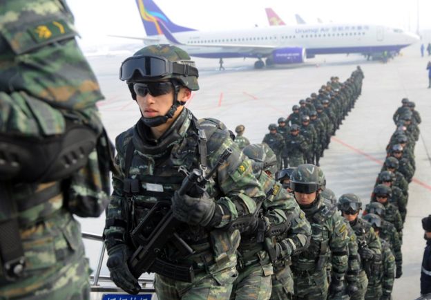 Paramilitary policemen board a plane as they head for an anti-terrorism oath-taking rally in Kashgar, from Urumqi, Xinjiang Uighur Autonomous Region, China, 27 February 2017.