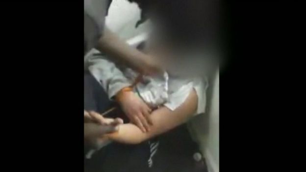 Still from video showing victim's clothing ripped