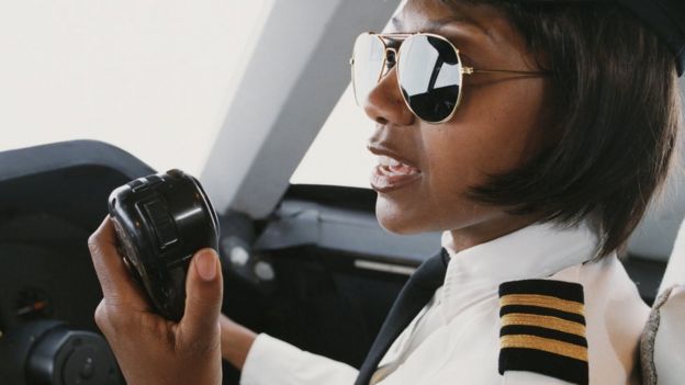Una mujer piloto comunicándose a través de la radio desde el avión.