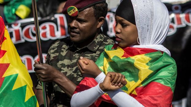 A demonstrator (L) dressed in military fatigue joins members of the Oromo, Ogaden and Amhara community in South Africa as they demonstrate against the ongoing crackdown in the restive Oromo and Amhara region of Ethiopia on August 18, 2016 in Johannesburg