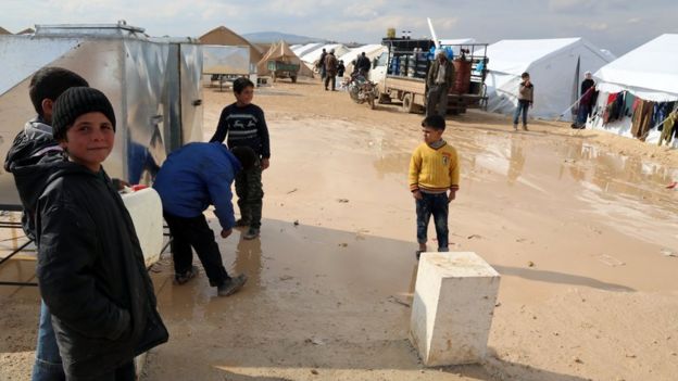 Photo provided by Turkish aid group IHH shows displaced Syrians outside tents at a new temporary camp in Haramein in Syria, near the border with Turkey (11 February 2016)