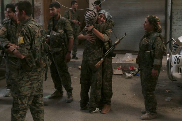 SDF fighters celebrate inside Manbij, Syria, 10 August