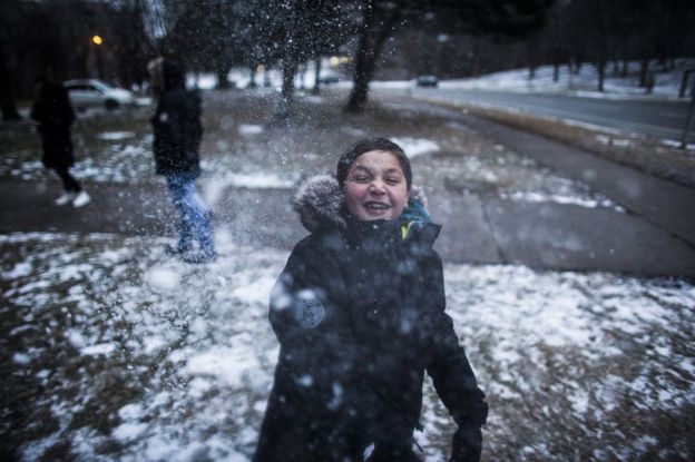 Syrian refugee Nasimi Alhasan plays in the snow outside of their apartment building in Mississauga, Ontario, Canada, Thursday January 21, 2016.
