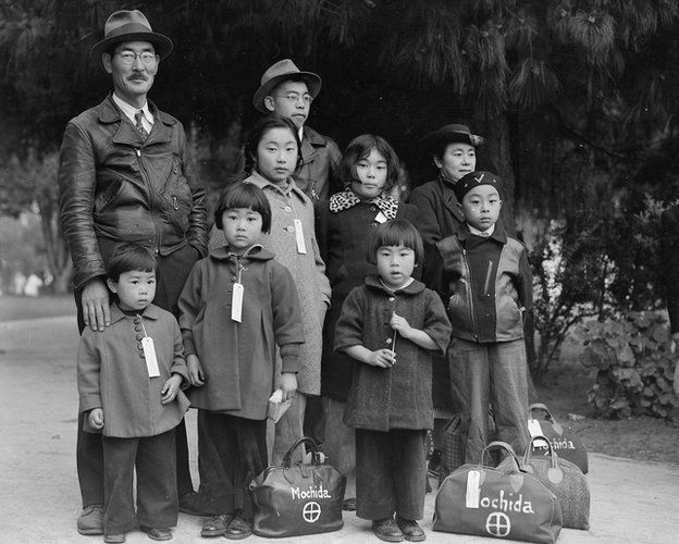 一个日本家庭在等候将他们运往禁闭营的巴士