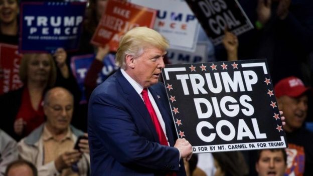 Republican presidential nominee Donald Trump holds a sign supporting coal during a rally at Mohegan Sun Arena in Wilkes-Barre, Pennsylvania (10 October 2016)