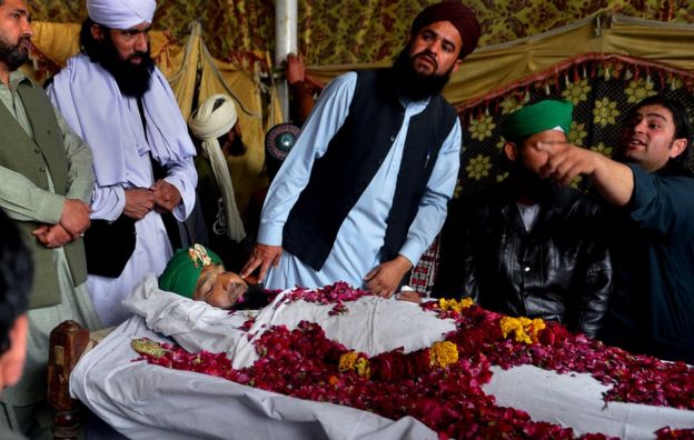 Relatives and supporters stand around the body of Mumtaz Qadri, the convicted killer of a former governor, during funeral ceremonies at his home in Rawalpindi, Pakistan, Monday, 29 February 2016.