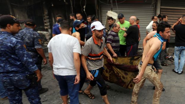 Iraqis evacuate body from site of suicide car bombing in Baghdad's central Karrada district. 3 July 2016