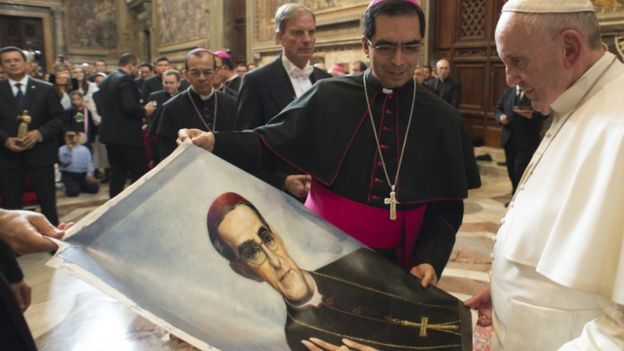 Pope Francis holds a picture of Oscar Romero in the Vatican, October 2015