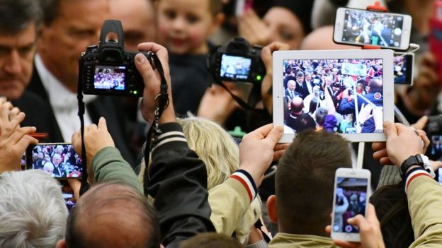 Gente tomando fotos al Papa