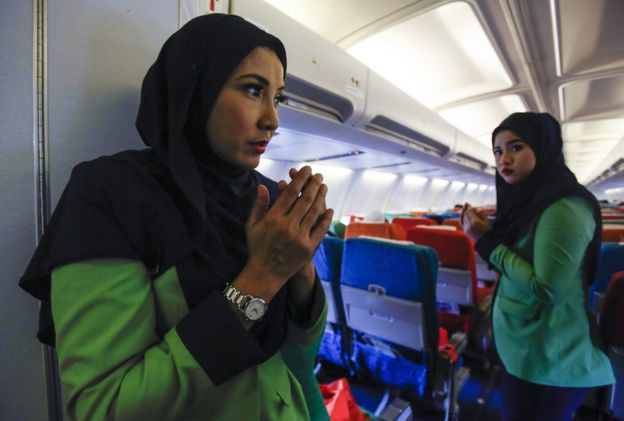 In this 22 December 2015, photo, Rayani Air flight crew pray before departure at Kuala Lumpur International Airport 2 in Sepang, Malaysia