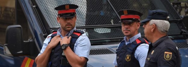Catalan police, like these in Barcelona on the left, have been ordered to accept the command of Spain's Civil Guard (R)