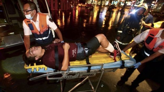 An injured man is helped by emergency rescue workers after an explosion on a passenger train in Taipei, Taiwan, Thursday, July 7, 2016