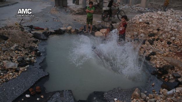 Photograph published by Aleppo Media Centre showing Syrian boys diving in a water-filled crater in the Sheikh Saeed district of Aleppo on 31 August 2016