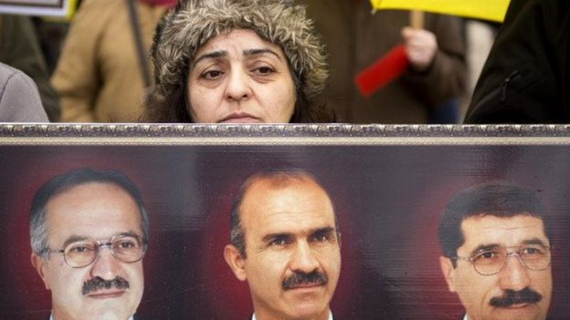 A member of the People's Mujahedin Organisation of Iran in Paris holds pictures of members Abbas Namvar, Mohammad-Javad Saleh-Tehrani and Mahmoud Bornafar who were killed in a 2013 attack on Camp Liberty