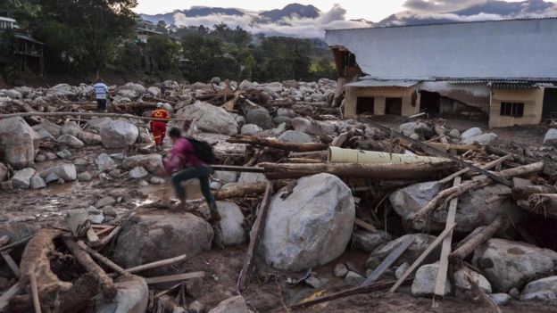 People walk through the rubble left by mudslides following heavy rains in Mocoa, Putumayo department, southern Colombia on April 1, 2017.