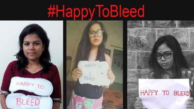 Women holding #HappyToBleed posters