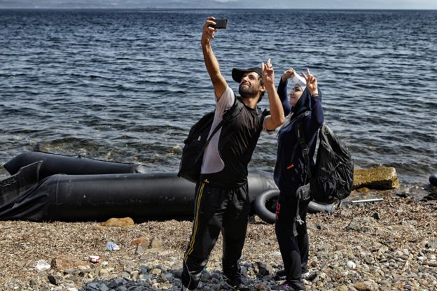 Refugees take selfie by beach