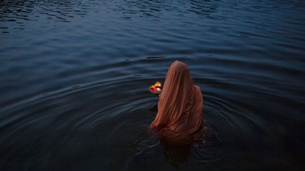 An Indian women offers early-morning prayers or a 'puja' at a ghat early in the morning on the banks of the Betawa River in Orchha in the state of Madhya Pradesh on July 5, 2015