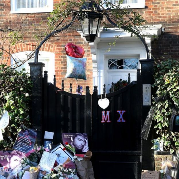 Flores y otros tributos a la puerta de la casa de George Michael en Londres