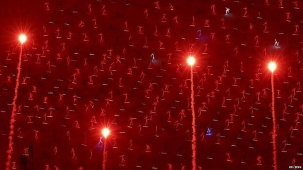 Children perform alongside fireworks at a parade rehearsal, 1 Aug