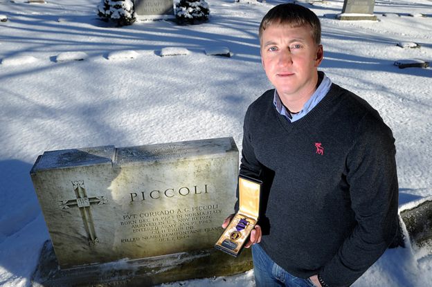 Zachariah Fike at the grave of the first Purple Heart recipient he traced
