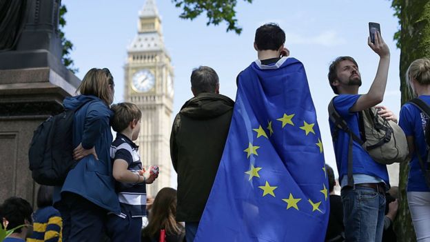 Un joven envuelto en una bandera de la UE observa el Big Ben.