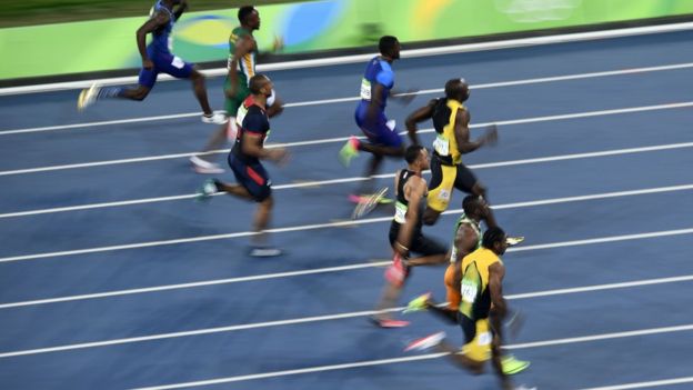 Usain Bolt com outros três competidores na prova dos 100 metros