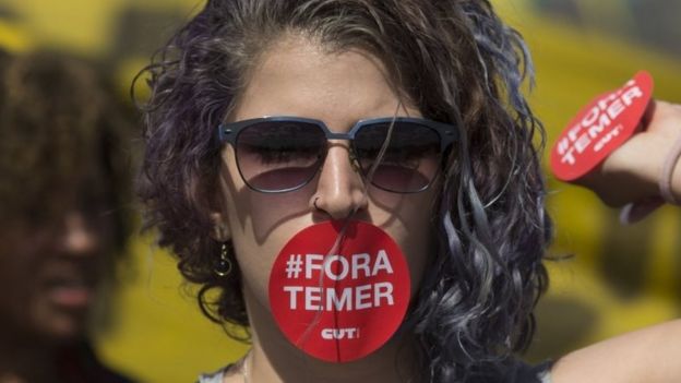 A supporter of Dilma Rousseff, her mouth covered with a sticker that reads in Portuguese; 