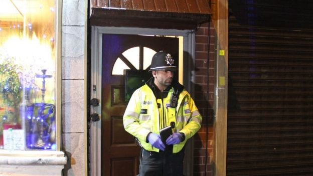 Un policía frente a la puerta de una de las viviendas allanadas en Birmingham.