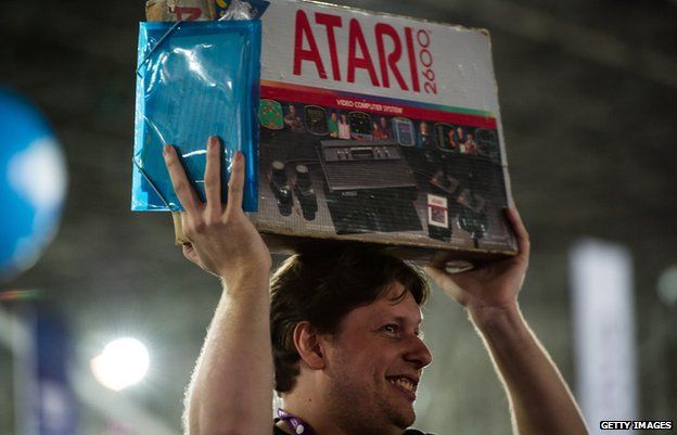 Man holding Atari 2600 box