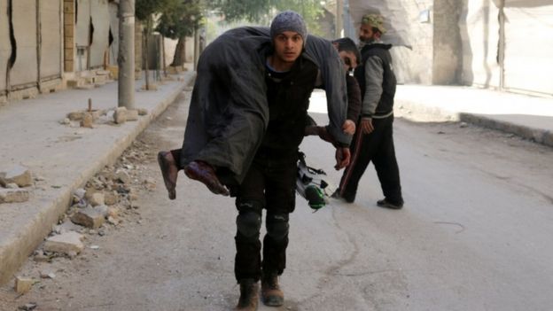 A Syrian civil defence volunteer carries an injured man, 19 November