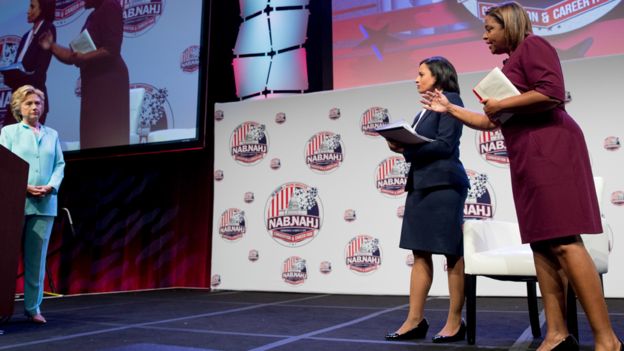 Telemundo reporter Lori Montenegro, right, accompanied by NBC reporter Kristen Welker, second from right, asks Democratic presidential candidate Hillary Clinton a question at the 2016 National Association of Black Journalists