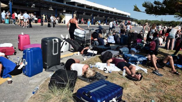 Tourists gather outside terminal buildings at an airport on the island of Kos following an earthquake, 21 July 2017