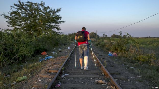 A migrant, hoping to cross into Hungary, walks along a railway track near the village of Horgos in Serbia, towards the border it shares with Hungary, September 1, 2015.