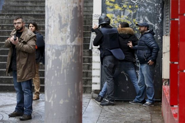 French police check a pedestrian as they secure the area after a man was shot dead at a police station in the 18th district in Paris, France 7 January 2016