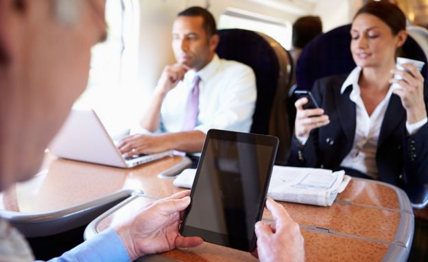 Rail passengers working on laptops an tablets