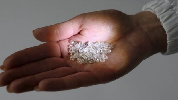 An employee shows rough diamonds at a sorting centre, owned by Alrosa company, in Moscow (19 October 2015)
