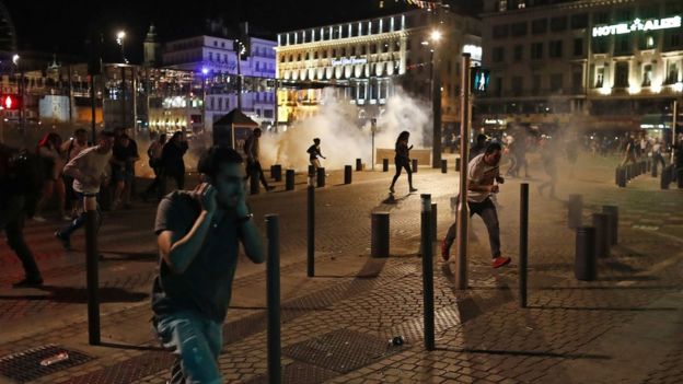 People run after police fired tear gas following clashes after the Euro 2016 soccer championship group B match between England and Russia in Marseille