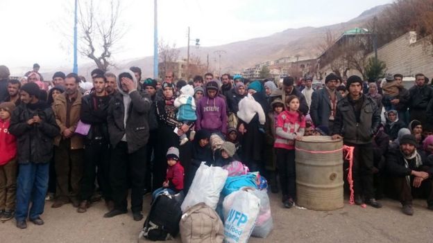 Syrians wait for the arrival of an aid convoy in the besieged town of Madaya on 11 January 2016