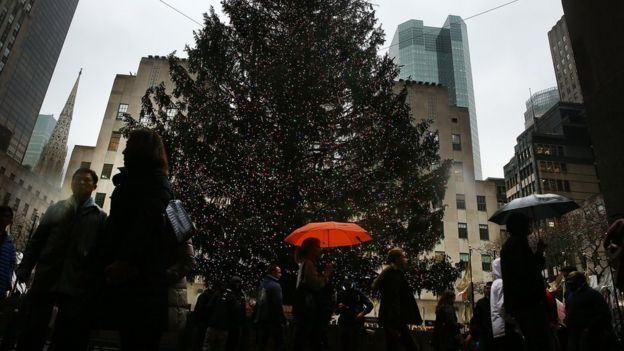 People walk past the Christmas tree at Rockefeller Centre on December 22, 2015 in New York City